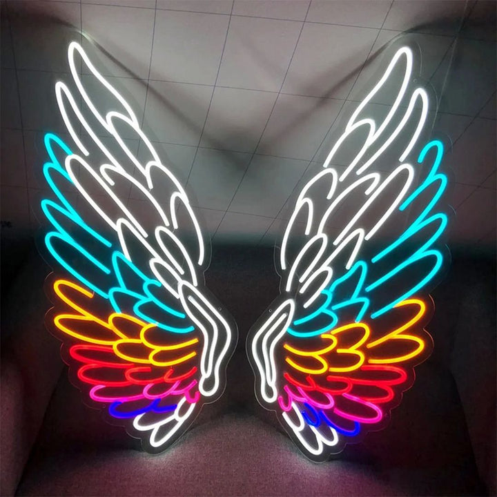 It's a multi-colored Angel Wings Neon Sign leaning against the wall |ManhattanNeons