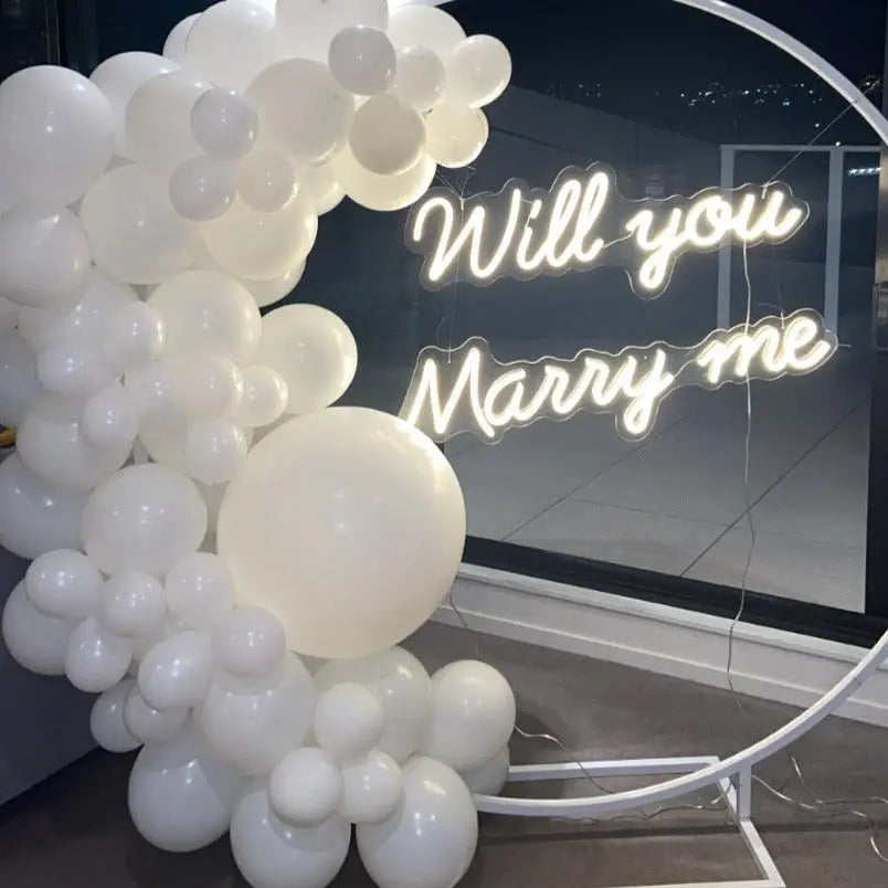 Capture the moment with the Will You Marry Me wedding neon sign from ManhattanNeons.com, surrounded by enchanting balloons.