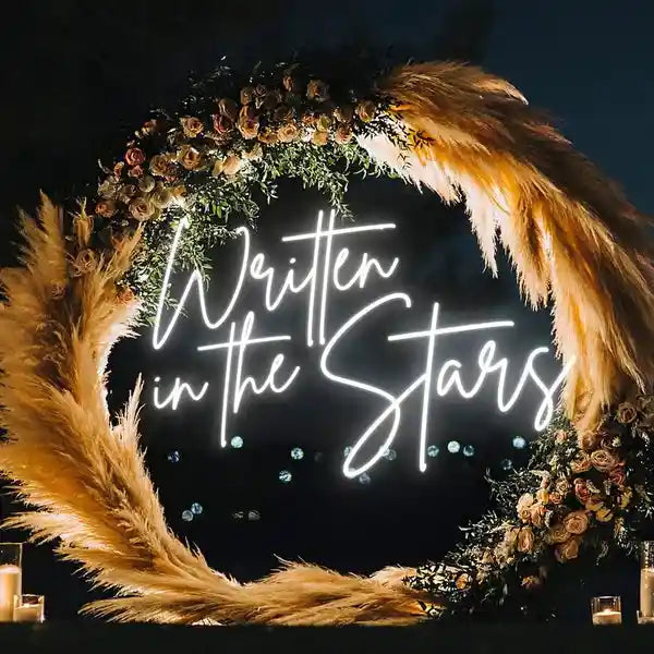 Captivating Written In The Stars wedding neon sign by ManhattanNeons.com, surrounded by enchanting rounded flowers in the dark.